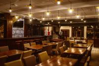 ein Restaurant mit Holztischen und Stühlen und Lichtern in der Unterkunft Pousada Relíquias do Tempo in Diamantina