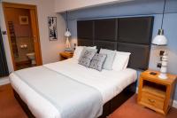1 dormitorio con 1 cama blanca grande y cabecero grande en New Wilmington Hotel, en Eastbourne