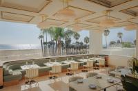 a restaurant with tables and chairs and the beach at Regent Santa Monica Beach in Los Angeles