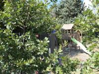 a playground in a garden with a tree at La Grisonne - Chalet 3 in Revest-du-Bion