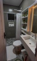 a bathroom with a toilet and a sink and a tv at La Estancia Residencial in Iguape