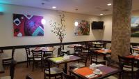 een eetkamer met tafels en stoelen en schilderijen aan de muur bij HOTEL ValgrandE in Coatzacoalcos
