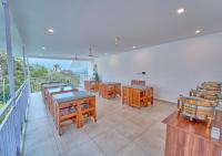 um restaurante com mesas e cadeiras de madeira numa varanda em Ice Mist Pool Resort Munnar By VOYE HOMES em Munnar