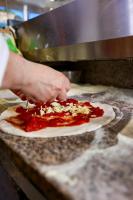 a person making a pizza on a counter at Boca Beach Residence hotel in Boca Chica