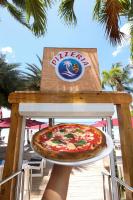 a person holding a pizza on top of a table at Boca Beach Residence hotel in Boca Chica