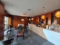 ein Restaurant mit Tischen und Stühlen und eine Bar in der Unterkunft Room at Langkawi Lagoon Private Residence in Pantai Cenang