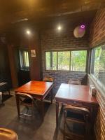 2 mesas de madera en una habitación con una pared de ladrillo en 淡路島 サウナ宿たんざ, en Awaji