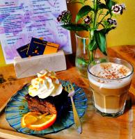 un pedazo de pastel en un plato junto a una bebida en ApartHotel Waepen van Middelburg, en Middelburg