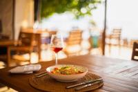 a bowl of food and a glass of wine on a table at The MAVERICK SURF AND DIVE BOUTIQUE HOTEL - Book 10 Nights and get 1 Free Night - Free Speed Boat Service - Kids Stay Free in Laamu