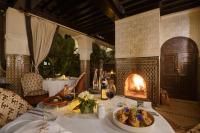 a table with a plate of food and a fireplace at Riad Kheirredine in Marrakech