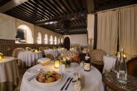 a restaurant with tables with white table cloths and a plate of food at Riad Kheirredine in Marrakech