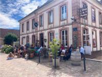 eine Gruppe von Menschen, die vor einem Gebäude sitzen in der Unterkunft Aux lapins Bleus in La Ferté-Vidame