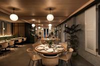 a dining room with tables and chairs and lights at The Warehouse Hotel, Singapore, a Member of Design Hotels in Singapore