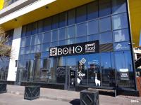 阿斯塔纳Expo Inn апартаменты напротив Ботанического сада的在建筑物侧面有招牌的商店