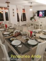 CălăţelePensiunea Anda的用餐室配有带白板和椅子的桌子