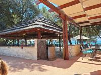 un bar con techo de paja en un patio en Mobile home Blue Lagoon 785, en Biograd na Moru