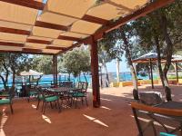 Un patio con mesas y sillas y el agua. en Mobile home Blue Lagoon 785, en Biograd na Moru