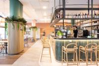 eine Bar in einem Restaurant mit Stühlen und einem Barkeeper in der Unterkunft Novotel Suites Marseille Centre Euromed in Marseille