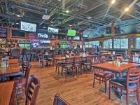 a restaurant with wooden tables and chairs and televisions at 5 Min walk to the beach 1st floor condo Sleeps 4 in Hilton Head Island