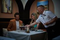 a man holding a plate of food at a table at Four Seasons Vilamoura in Vilamoura