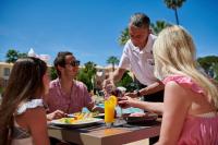 a group of people sitting at a table eating food at Four Seasons Vilamoura in Vilamoura