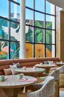 ein Restaurant mit Tischen und Stühlen und großen Fenstern in der Unterkunft La Concha Key West, Autograph Collection in Key West