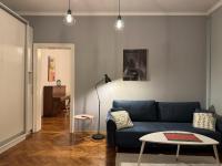 Una sala de estar con un sofá azul y una mesa. en Apartamenty Zasanie, en Przemyśl