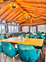 een eetkamer met een houten tafel en groene stoelen bij Royal Alpin Crown in Cavnic