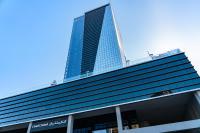 a tall building with a blue sky in the background at Canal Central Hotel Business Bay in Dubai