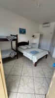 a room with two beds and a refrigerator at Hotel Nils in Itapoa