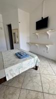 a room with a bed and a tv on a wall at Hotel Nils in Itapoa