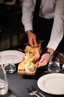 a person holding a tray of food on a table at Vila Borova Wellness&SPA Resort in Zlatibor