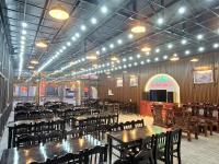 a large room with tables and chairs and a stage at Van Anh Hotel - Restaurant in Dồng Văn