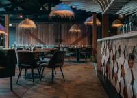 ein Restaurant mit einer Bar mit Stühlen und Tischen in der Unterkunft Groepsvilla | 24 personen in Voorthuizen