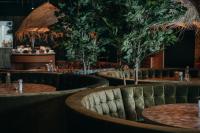 een restaurant met tafels en potbomen bij Glamping De Boshoek in Voorthuizen