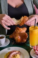 Maleyssie Les Suites في شارتر: امرأة تمسك صحن من الطعام وكأس من عصير البرتقال