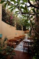 Una fila de mesas y sillas en una habitación con plantas. en Villa Mango Hotel, near the American University in Cairo, AUC, New Cairo, en El Cairo