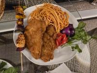 talerz jedzenia z kurczakiem i makaronem na stole w obiekcie Blue Lotus Nile Suites Hotel Aswan w mieście Aswan