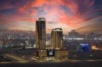 a city skyline with two tall buildings at night at voco Jeddah Gate by IHG in Jeddah