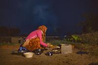 Una mujer está preparando comida en un campo. en The Beehad Sariska, en Tehla