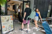 a man and a woman walking down a street with luggage at Never at Home Kloof Street in Cape Town