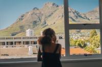 a woman looking out a window at a mountain at Never at Home Kloof Street in Cape Town