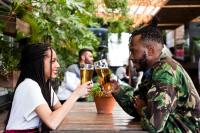 a man and a woman drinking beer at a table at Never at Home Kloof Street in Cape Town