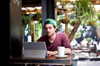 a man sitting at a table with a laptop computer at Never at Home Kloof Street in Cape Town