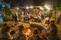 a group of people sitting around a fire pit at Never at Home Kloof Street in Cape Town