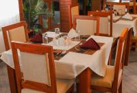 een eettafel met een witte tafeldoek erop bij River House Lodge in Arusha