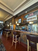 ダゲナムにあるThe Eastbrook Pub & Hotelの木製の壁と椅子が備わるパブ内のバー