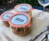 Un frasco de comida en una mesa junto a una copa de vino. en Logis Manoir De La Giraudière, en Beaumont-en-Véron