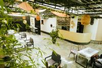 een restaurant met tafels, stoelen en planten bij Kalih Villa in Kigali