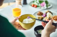 eine Person, die eine Schüssel Reis mit Stäbchen hält in der Unterkunft Holiday Inn Kyoto Gojo in Kyoto